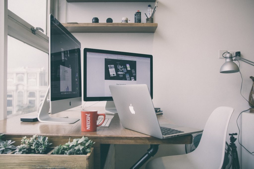 Image d'un bureau en bois avec multiples ordinateurs